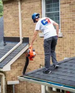 CR Cleaning Pros worker cleaning gutters/eavestroughs on a house in kitchener